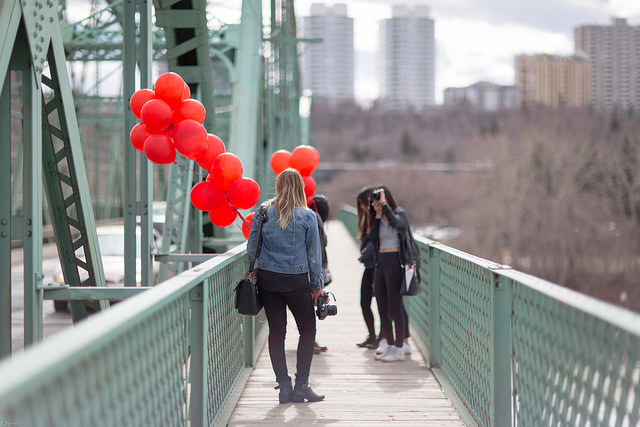 Girl holding red balloons on Waterdale bridge in Waterdale Edmonton