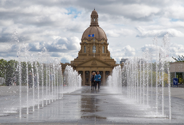 Two people walking through the fountains at Legislative Assembly of Alberta in Edmonton